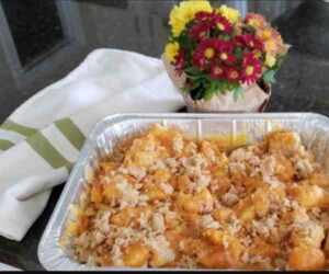 Tray of pumpkin and bread uncooked w flowers in background