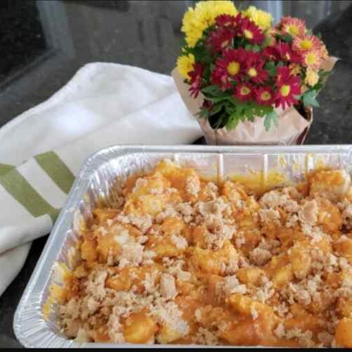 Tray of pumpkin and bread uncooked w flowers in background