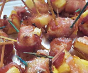 Chunks of pineapple wrapped in crispy bacon secured with toothpicks