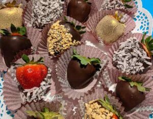 Assorted strawberries dipped in chocolate with gold, nuts, and coconut