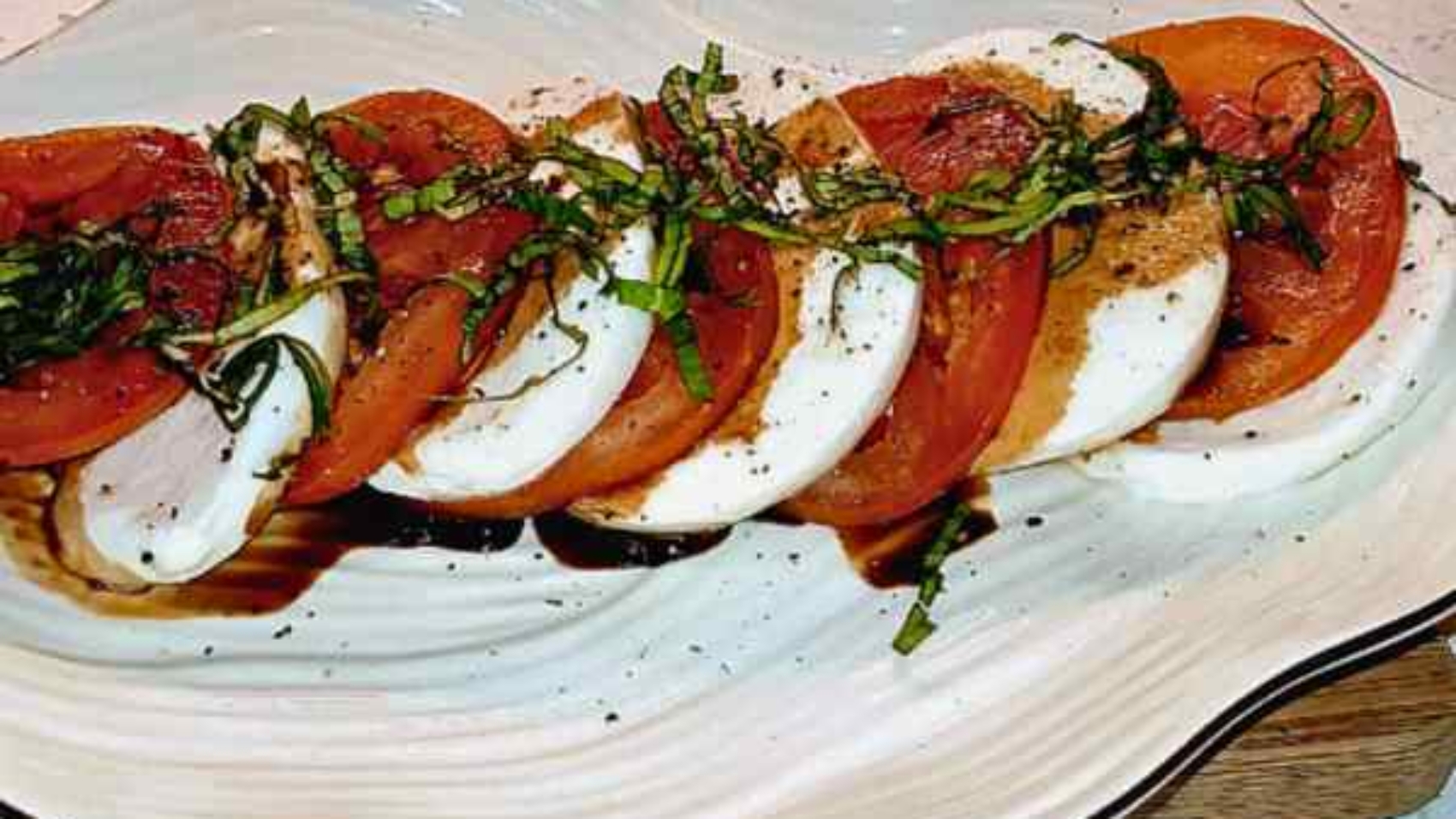 Sliced red tomatoes with alternating slices of mozzarella cheese