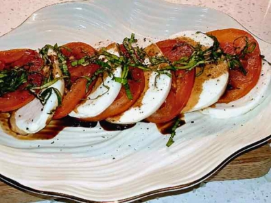 Sliced red tomatoes with alternating slices of mozzarella cheese