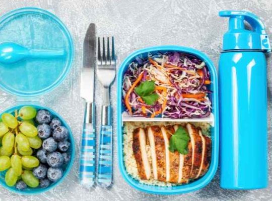lunch container with chicken and rice with grapes and thermos