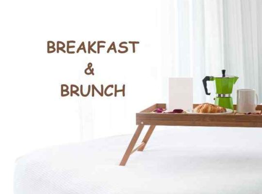 Breakfast tray with green coffee pot on a bed